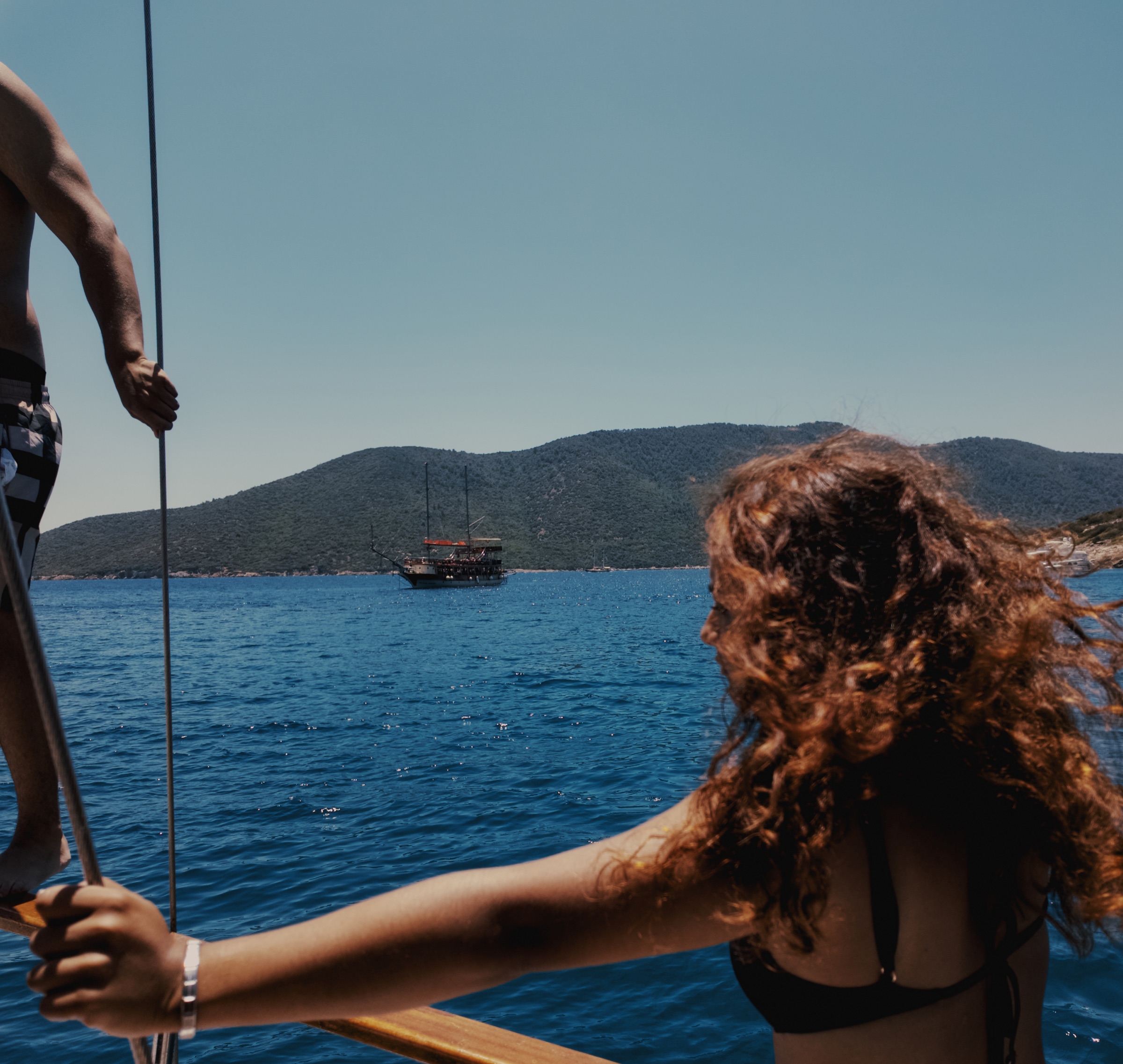 Woman on a boat in vivid blue water near Kara Ada